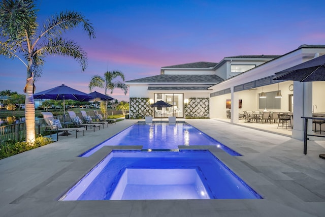 view of swimming pool featuring a patio area, fence, a fenced in pool, and an in ground hot tub