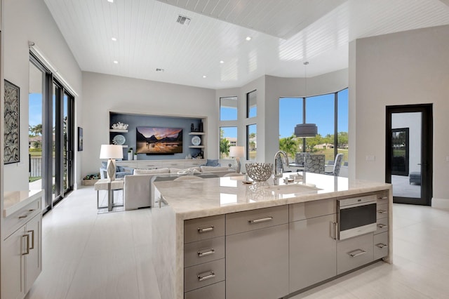 kitchen featuring wood ceiling, light stone counters, gray cabinets, and visible vents