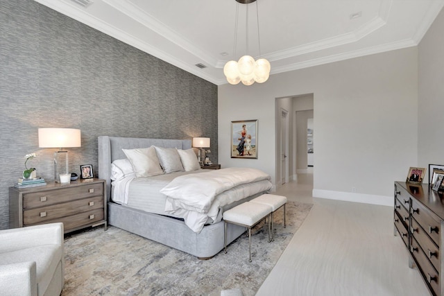 bedroom featuring baseboards, an accent wall, a tray ceiling, and ornamental molding