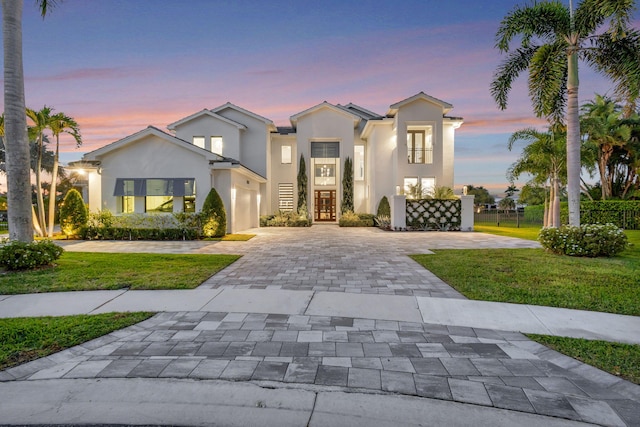 mediterranean / spanish house with a front yard, decorative driveway, and stucco siding