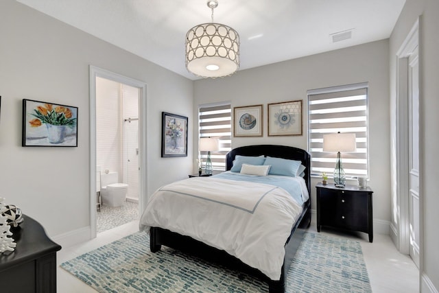 bedroom featuring visible vents, ensuite bath, and baseboards