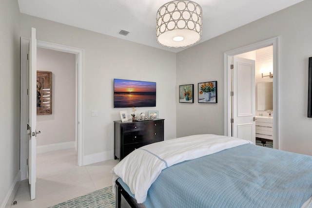 bedroom with light tile patterned floors, ensuite bathroom, visible vents, and baseboards