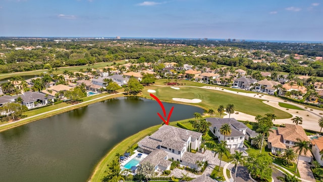 drone / aerial view with view of golf course, a water view, and a residential view