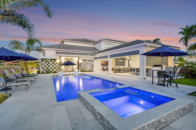 view of swimming pool with outdoor dining area, a patio area, and a pool with connected hot tub