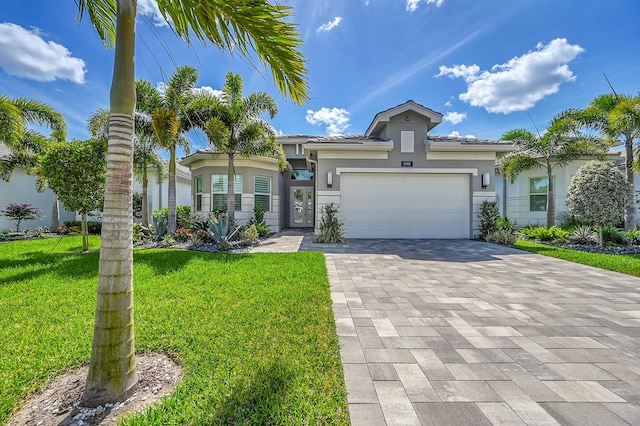 view of front of house featuring an attached garage, a tile roof, decorative driveway, stucco siding, and a front lawn