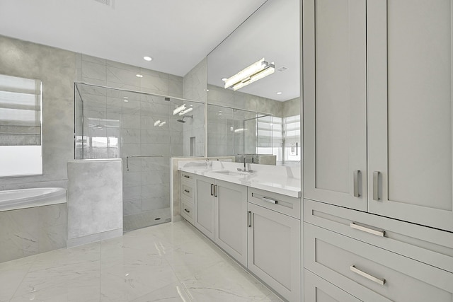 full bathroom with a stall shower, marble finish floor, vanity, a bath, and recessed lighting