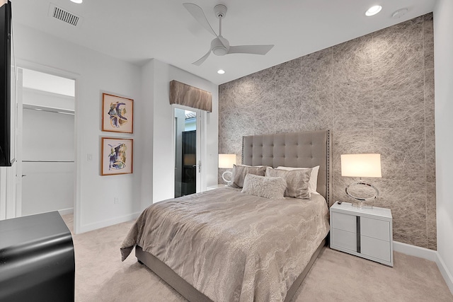 bedroom featuring baseboards, carpet floors, visible vents, and an accent wall