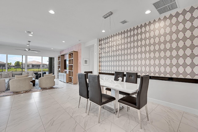 dining area with an accent wall, marble finish floor, and visible vents