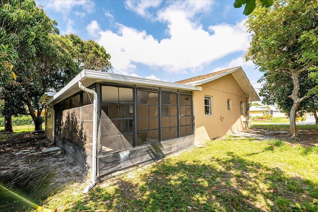 380 SE Crosspoint Dr, Port Saint Lucie, FL 34983 - rear view of property with a lawn, a sunroom, and stucco siding
