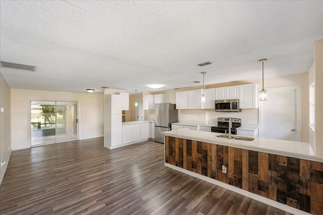 kitchen featuring stainless steel appliances, light countertops, white cabinets, and visible vents