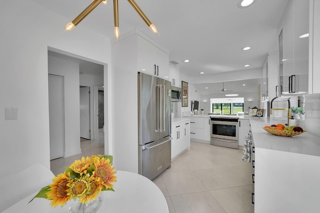 kitchen with white cabinets, modern cabinets, appliances with stainless steel finishes, and light countertops