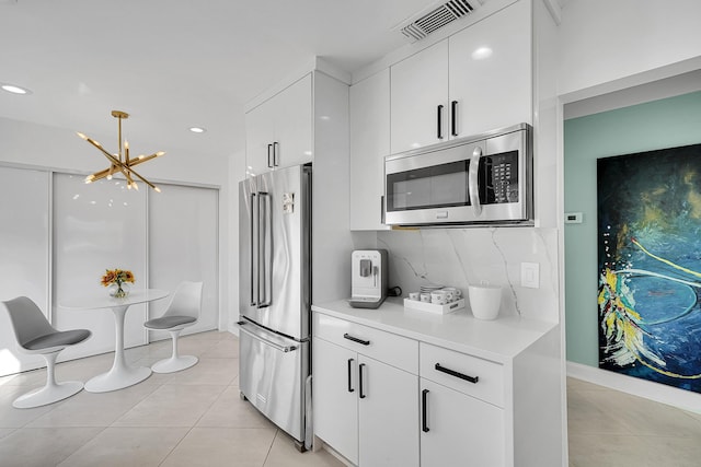 kitchen featuring light tile patterned floors, light countertops, appliances with stainless steel finishes, and white cabinetry