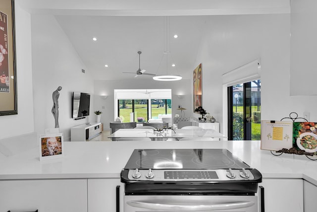 kitchen with high vaulted ceiling, white cabinetry, open floor plan, light countertops, and stainless steel range with electric stovetop