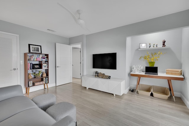 living area featuring light wood finished floors, visible vents, and baseboards