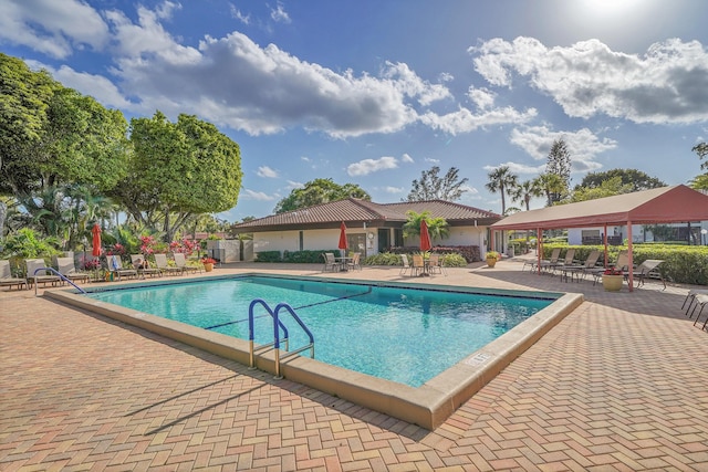 community pool featuring fence and a patio