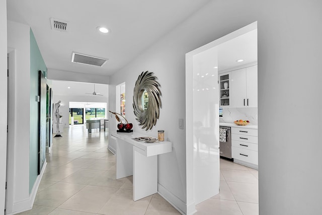 hallway with light tile patterned floors, baseboards, visible vents, and recessed lighting