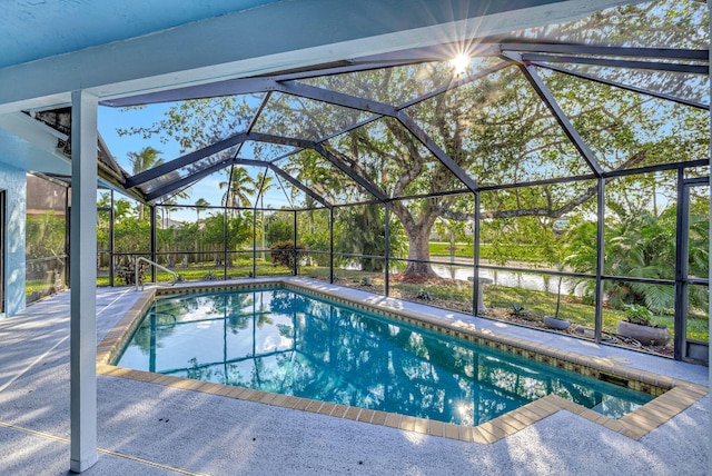 pool featuring glass enclosure and a patio area