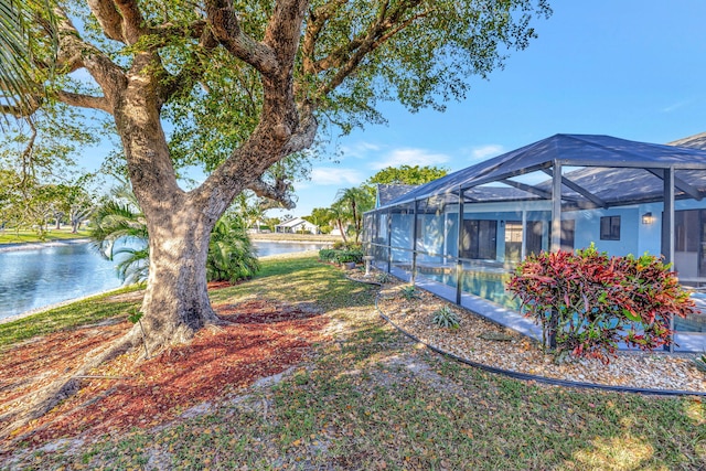 view of yard featuring glass enclosure, a water view, and an outdoor pool