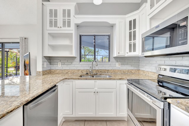 kitchen featuring stainless steel appliances, plenty of natural light, a sink, and decorative backsplash