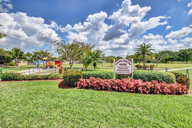 community / neighborhood sign with fence and a yard