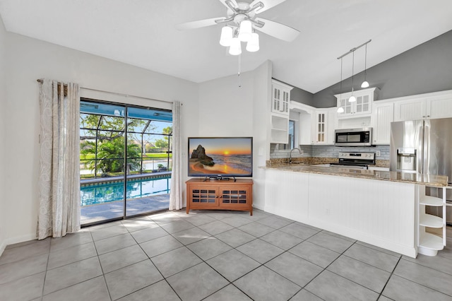 kitchen with open shelves, decorative backsplash, appliances with stainless steel finishes, a sink, and light stone countertops