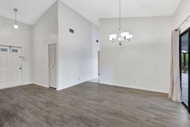 entryway featuring baseboards, visible vents, a chandelier, and wood finished floors