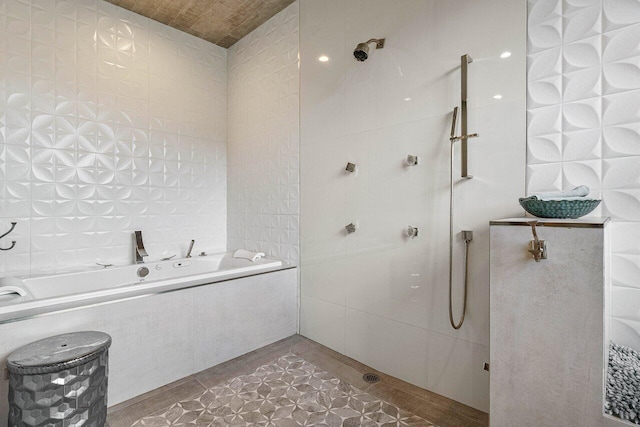 bathroom with a bath, a tile shower, and tile walls