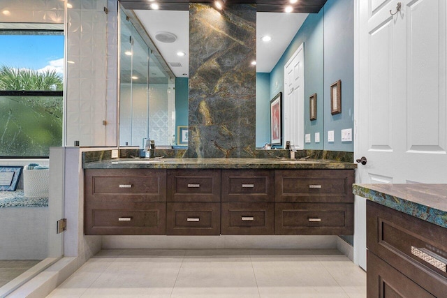 bathroom with double vanity, a sink, and tile patterned floors