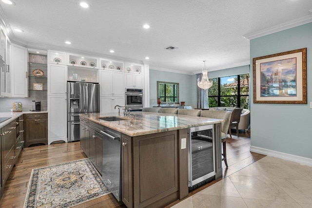 kitchen with wine cooler, visible vents, stainless steel appliances, and crown molding