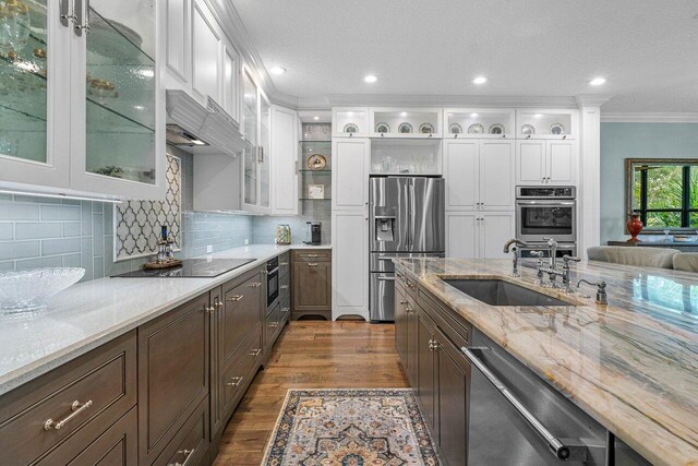 kitchen featuring dark wood-style floors, appliances with stainless steel finishes, a sink, and white cabinets