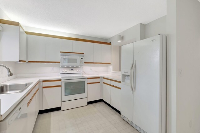 kitchen with white appliances, light countertops, and a sink