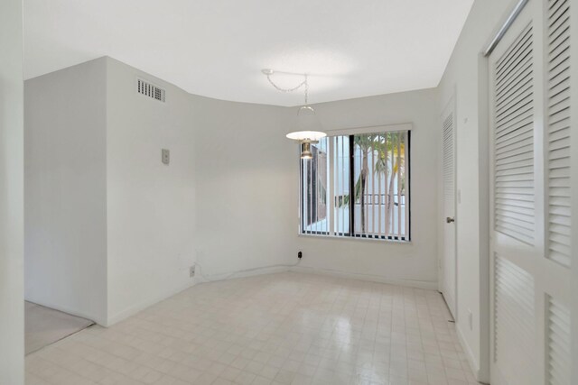 unfurnished room with baseboards and visible vents