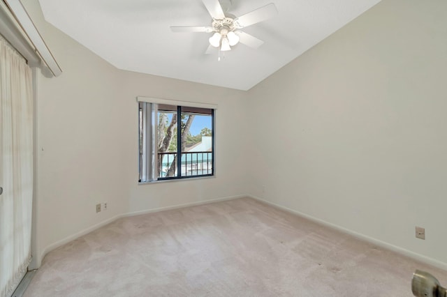 empty room featuring baseboards, light carpet, ceiling fan, and vaulted ceiling