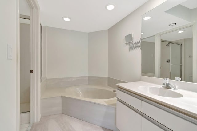 bathroom with recessed lighting, vanity, a bath, and a shower stall