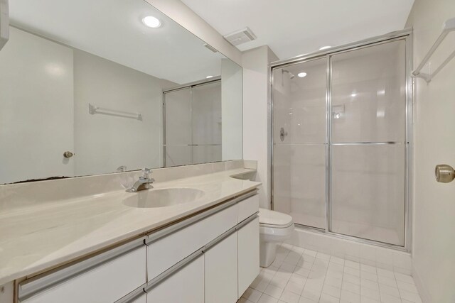 full bathroom with visible vents, toilet, a stall shower, tile patterned flooring, and vanity