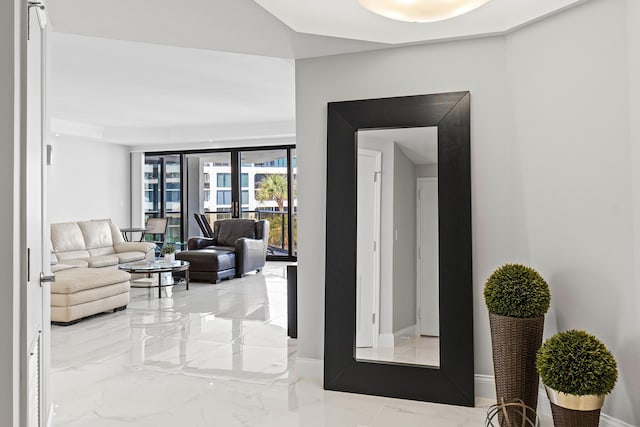 living area featuring marble finish floor, french doors, and baseboards