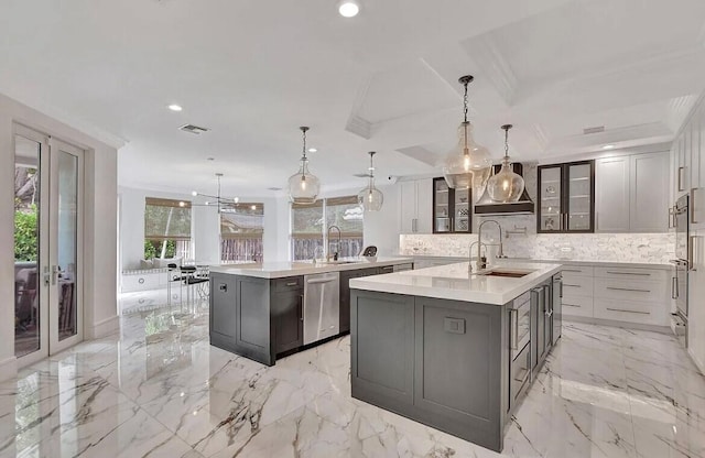 kitchen featuring marble finish floor, a kitchen island with sink, visible vents, and a sink