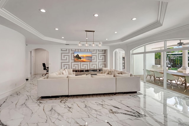 living area with ornamental molding, arched walkways, a raised ceiling, and recessed lighting