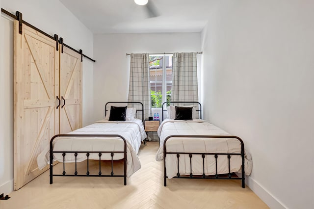 bedroom featuring a ceiling fan, baseboards, and a barn door