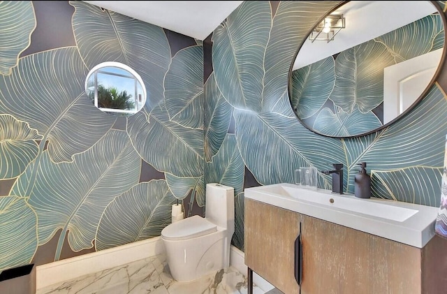 bathroom with toilet, marble finish floor, and vanity