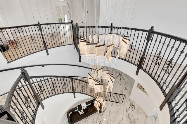 stairs with arched walkways and marble finish floor