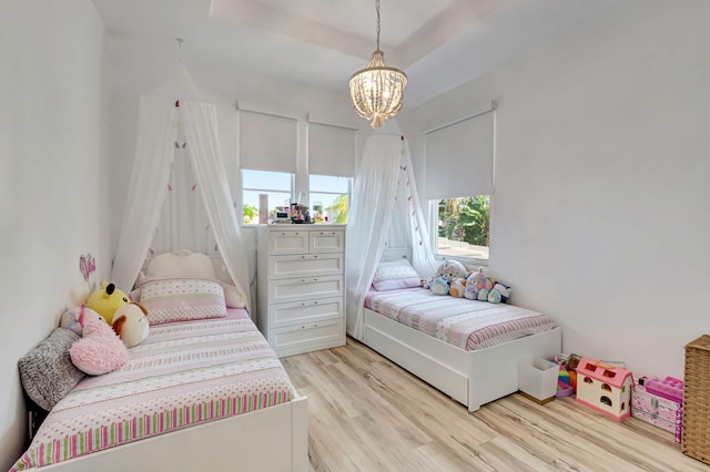 bedroom featuring a notable chandelier and light wood-style flooring