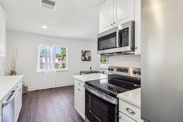 kitchen featuring visible vents, tasteful backsplash, appliances with stainless steel finishes, and a healthy amount of sunlight