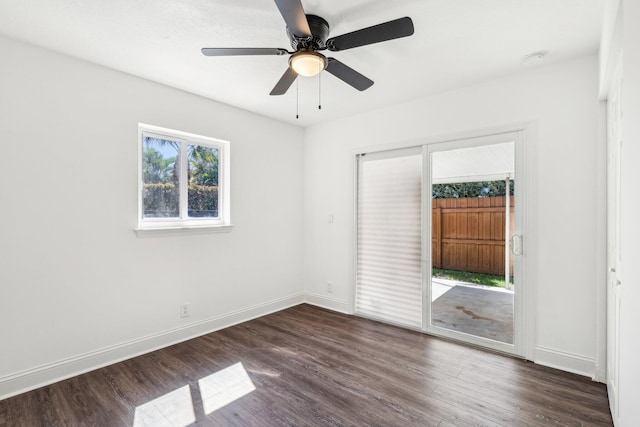 spare room featuring ceiling fan, baseboards, and dark wood finished floors