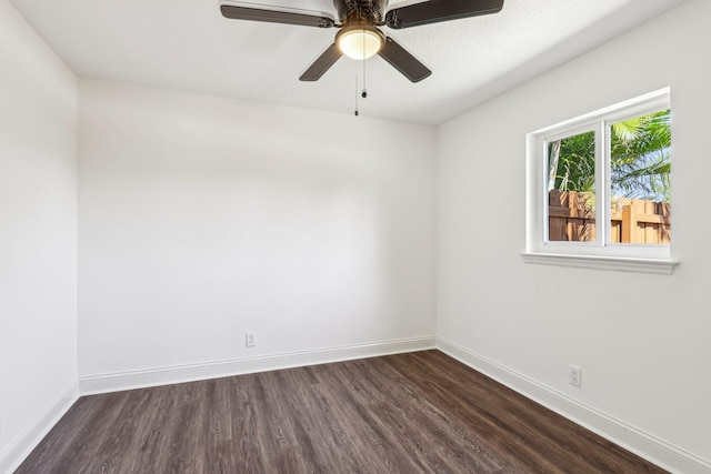 unfurnished room with dark wood-style floors, ceiling fan, and baseboards