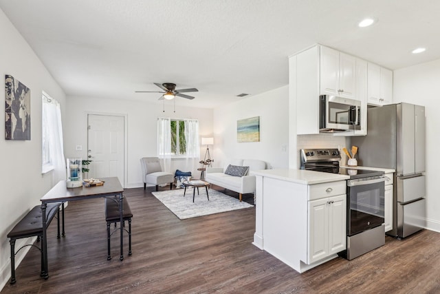 kitchen featuring decorative backsplash, dark wood-type flooring, appliances with stainless steel finishes, and white cabinets