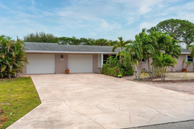 single story home featuring an attached garage, concrete driveway, and stucco siding