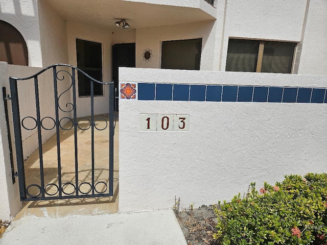 exterior space featuring a gate and stucco siding