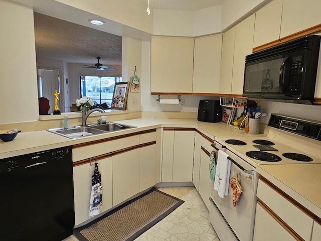 kitchen with light countertops, a textured ceiling, black appliances, a sink, and recessed lighting