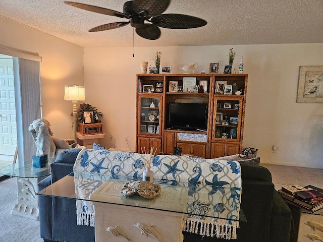 carpeted living area with a textured ceiling and a ceiling fan